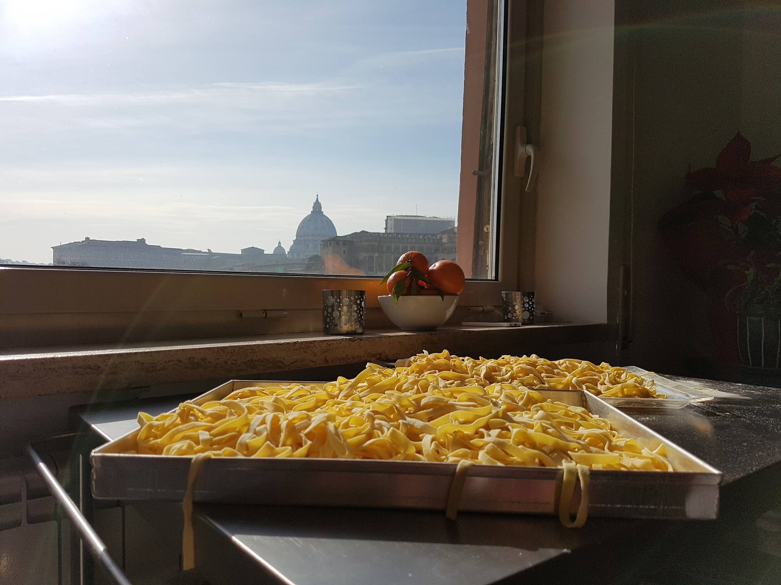 Trays of Fettuccine pasta with a view of the Vatican onthebackground